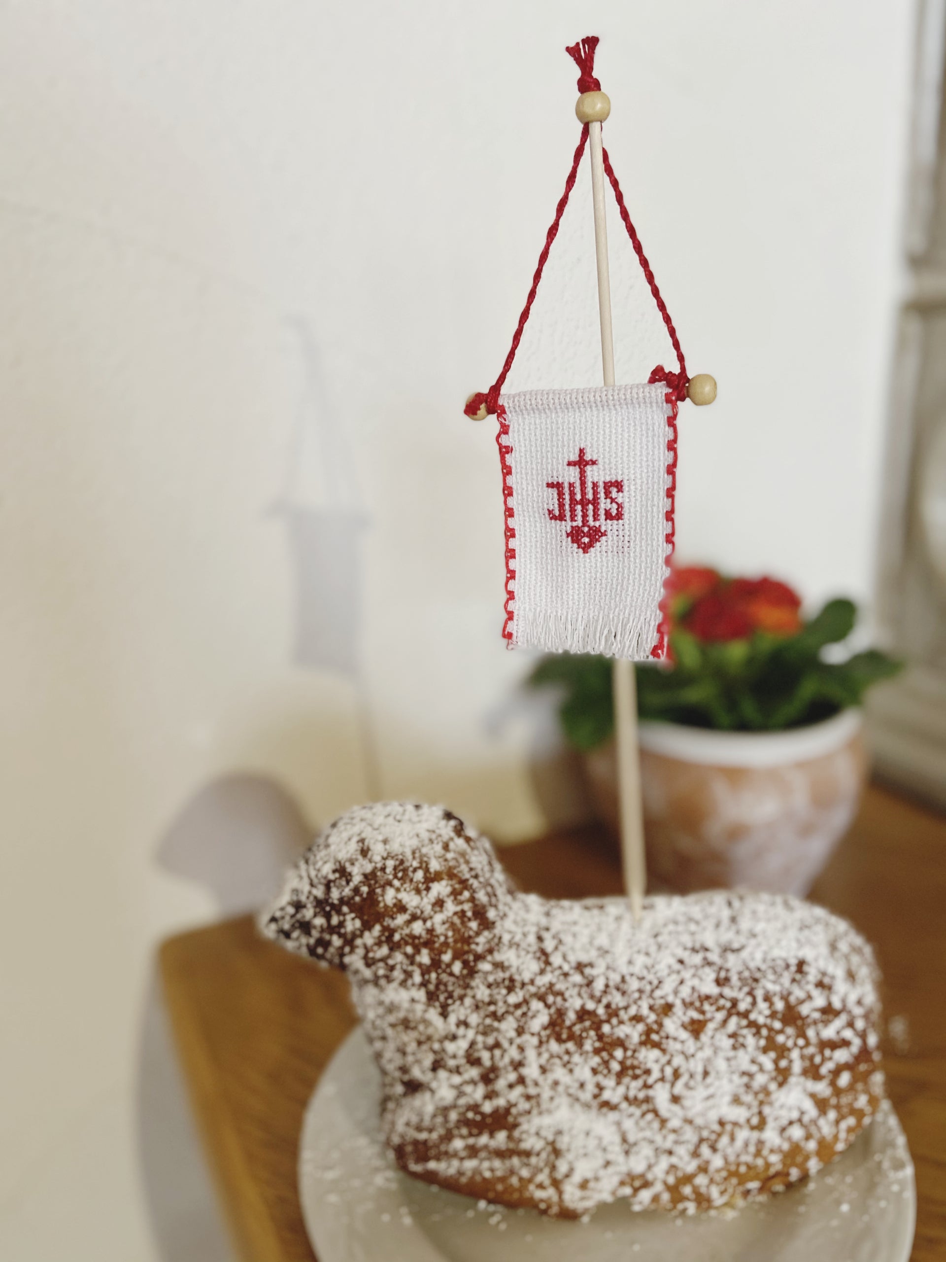 Beidseitig handbesticktes Osterfähnchen mit IHS-Motiv. Die Rückseite zeigt in allen Varianten ein Schaf-Motiv.